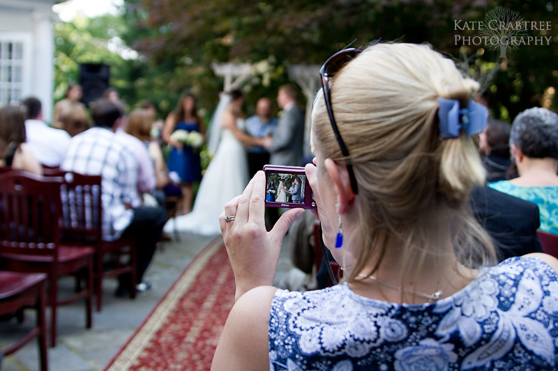 A guest takes a photo of the bride and groom in Camden Maine