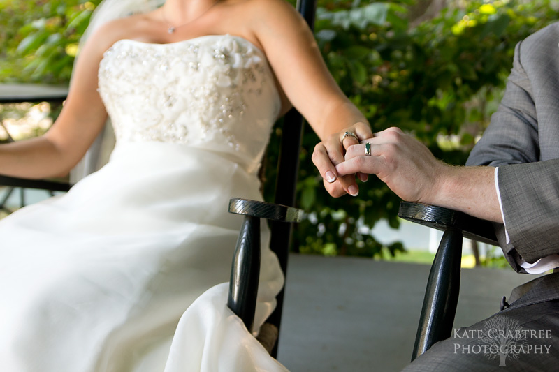 The bride and groom hold hands as they sit on the Whitehall Inn's front porch and enjoy the sunset.