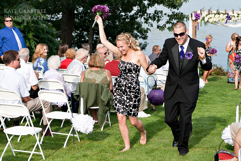 A bridemaid and groomsman dance down the aisle to celebrate their friends' wedding celebration at the Lakeview Golf Course in Maine