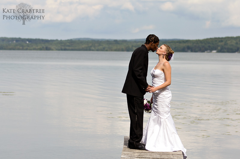 The bride and groom kiss in front of the stunning view at the Lakeview Golf Course in Central Maine