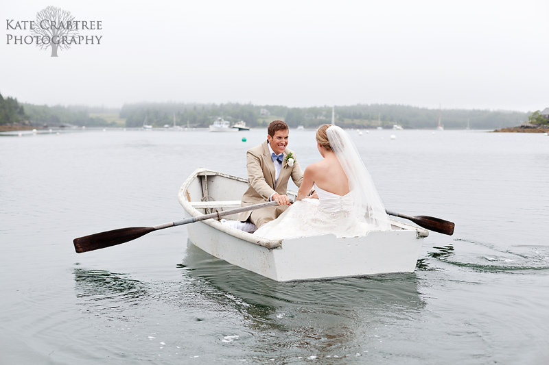 The bride and groom share a quiet moment in a rowboat after their lovely midcoast Maine wedding in this photo