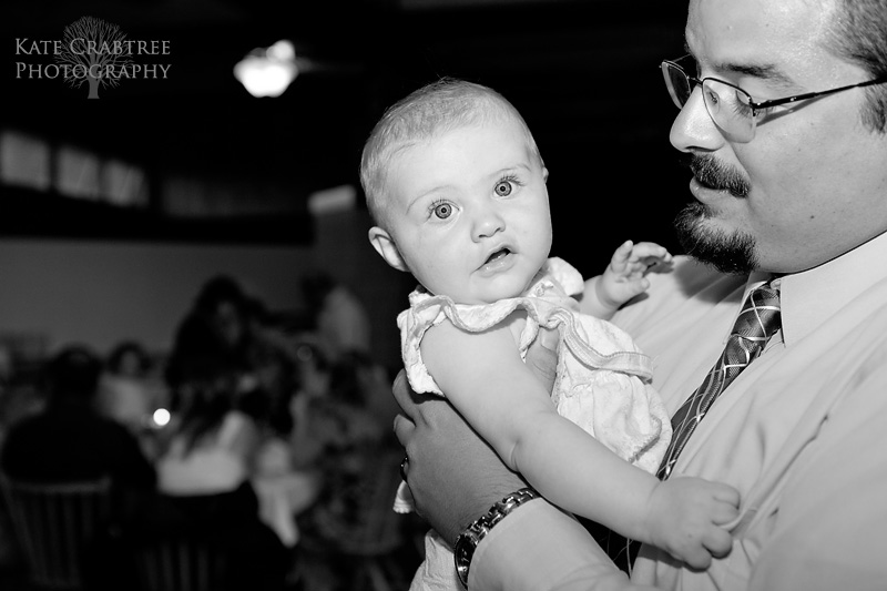 The groom interacts with a cute baby at his wedding in western maine