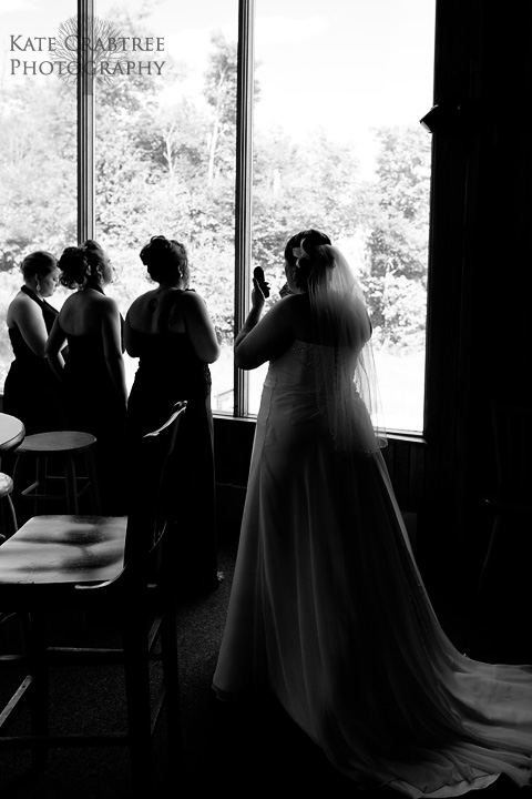 Maine wedding photographer Kate Crabtree captures the bridal party looking out the window at their western maine wedding