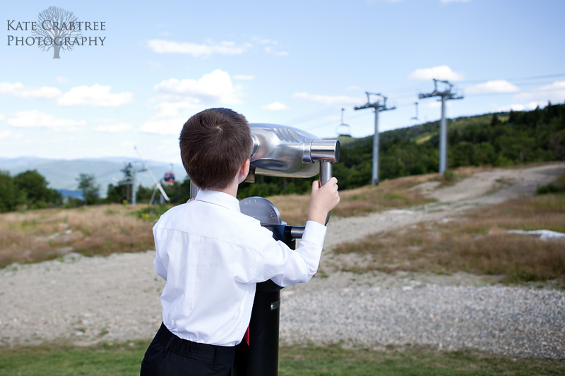 Maine wedding photographer Kate Crabtree captures the ring bearer checking out the view on top of Sunday River in western Maine