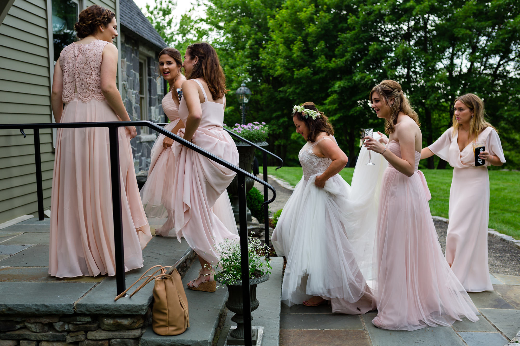 The bridesmaids help the bride bustle her wedding dress