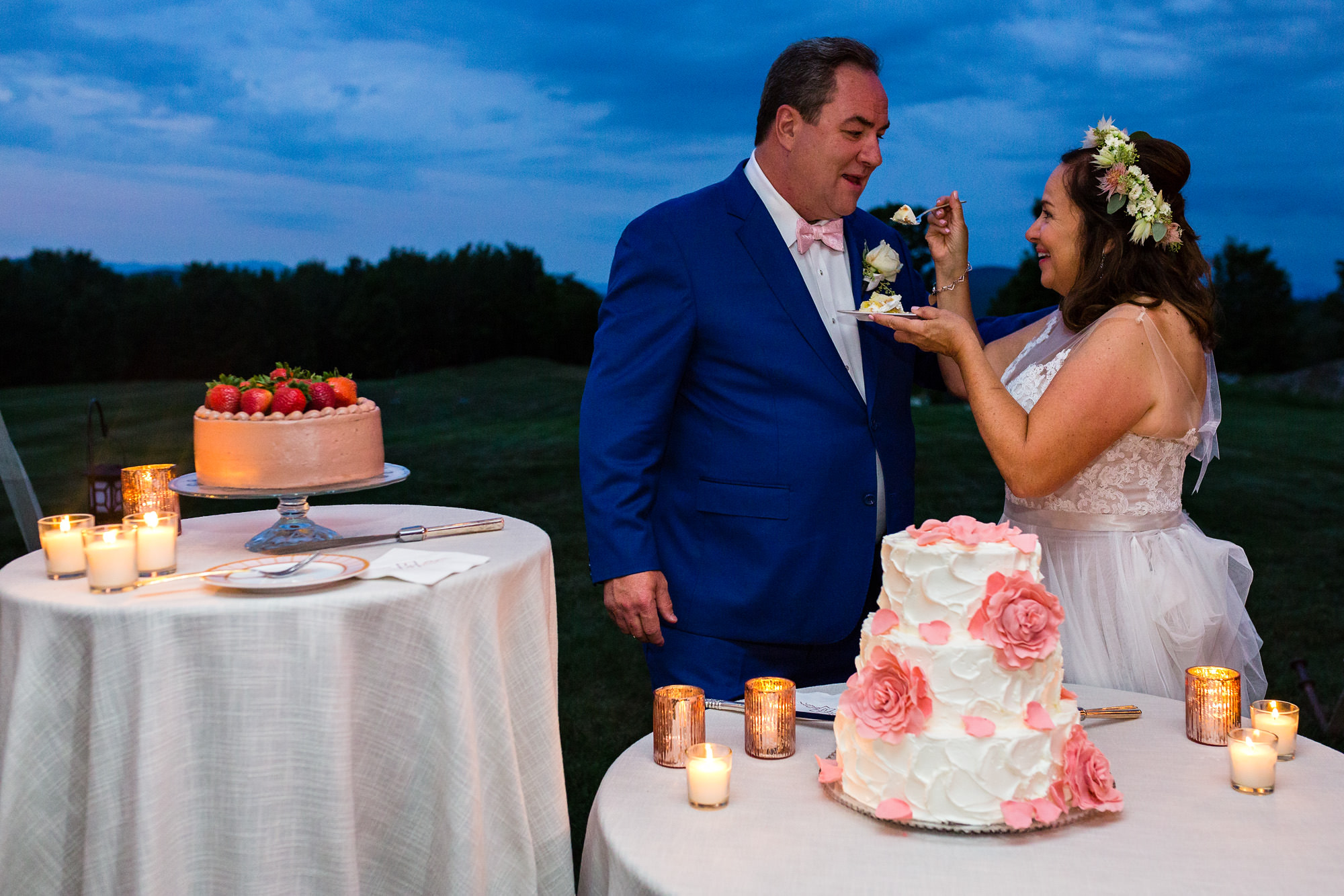 The bride and groom cut the wedding cake at twilight