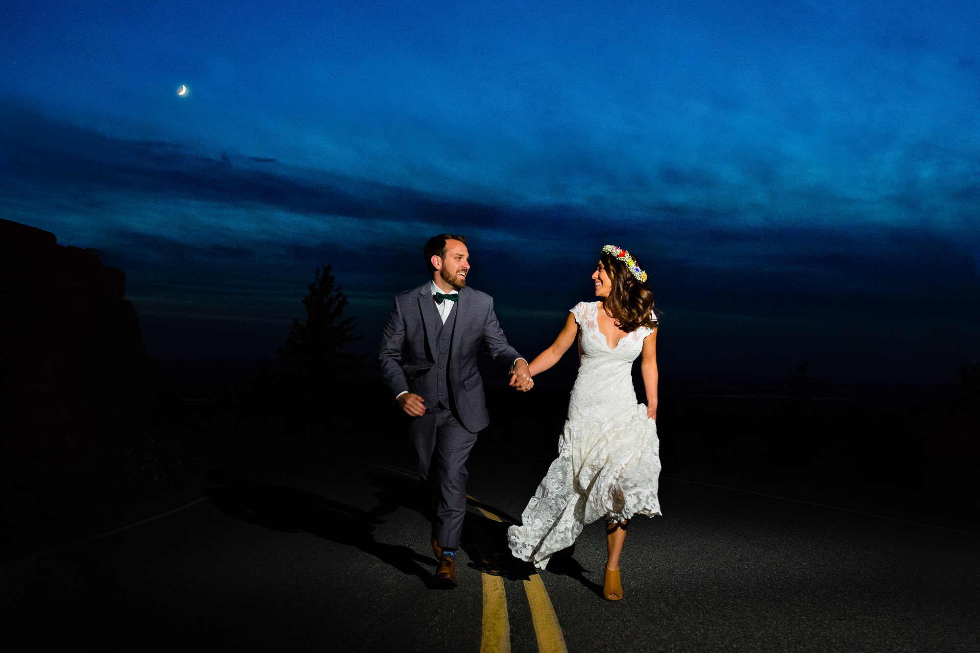 A bride and groom elope at twilight under the moon in Acadia National Park on Cadillac Mountain