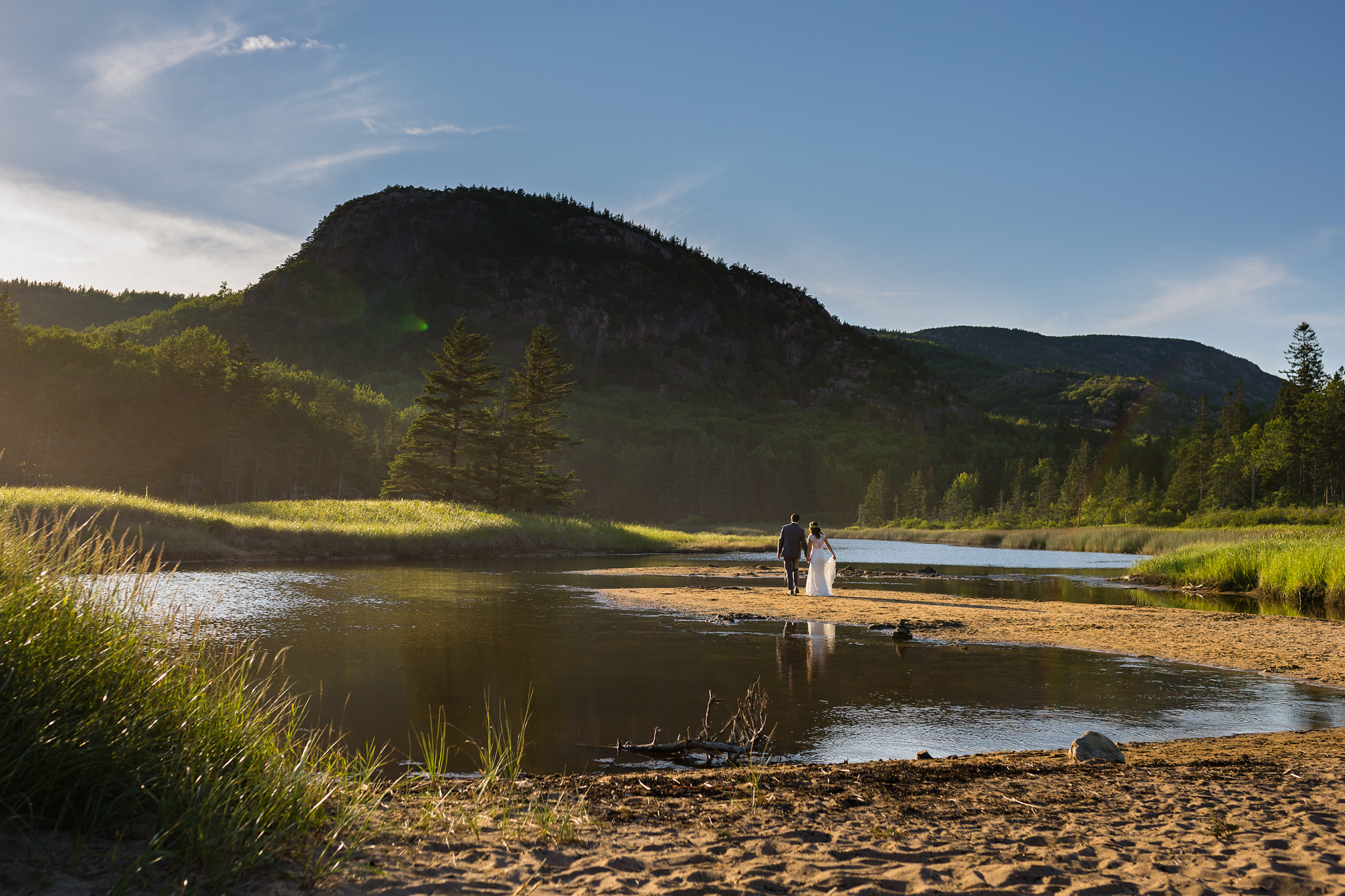 A bride and groom take portraits at Sand Beach after eloping in Acadia National Park