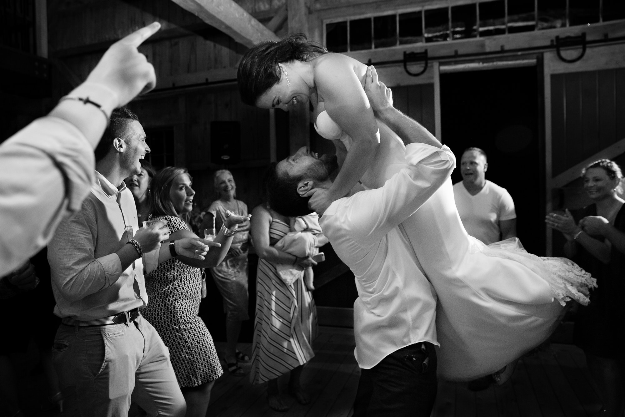 The bride and groom dance with friends and family at their destination barn wedding in Maine