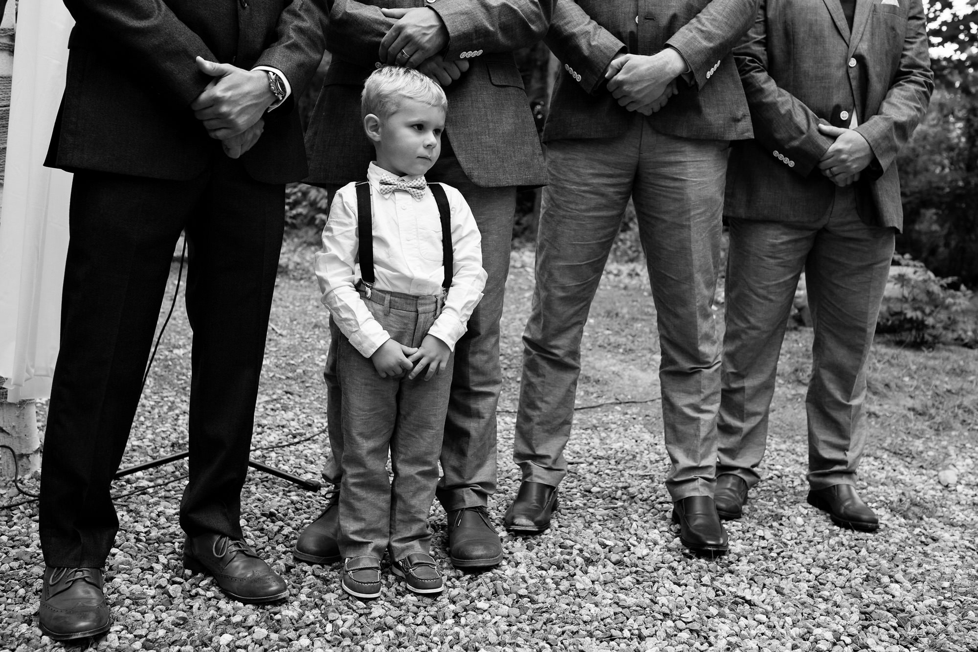 A ring bearer emulates the groomsmen at a Maine wedding ceremony