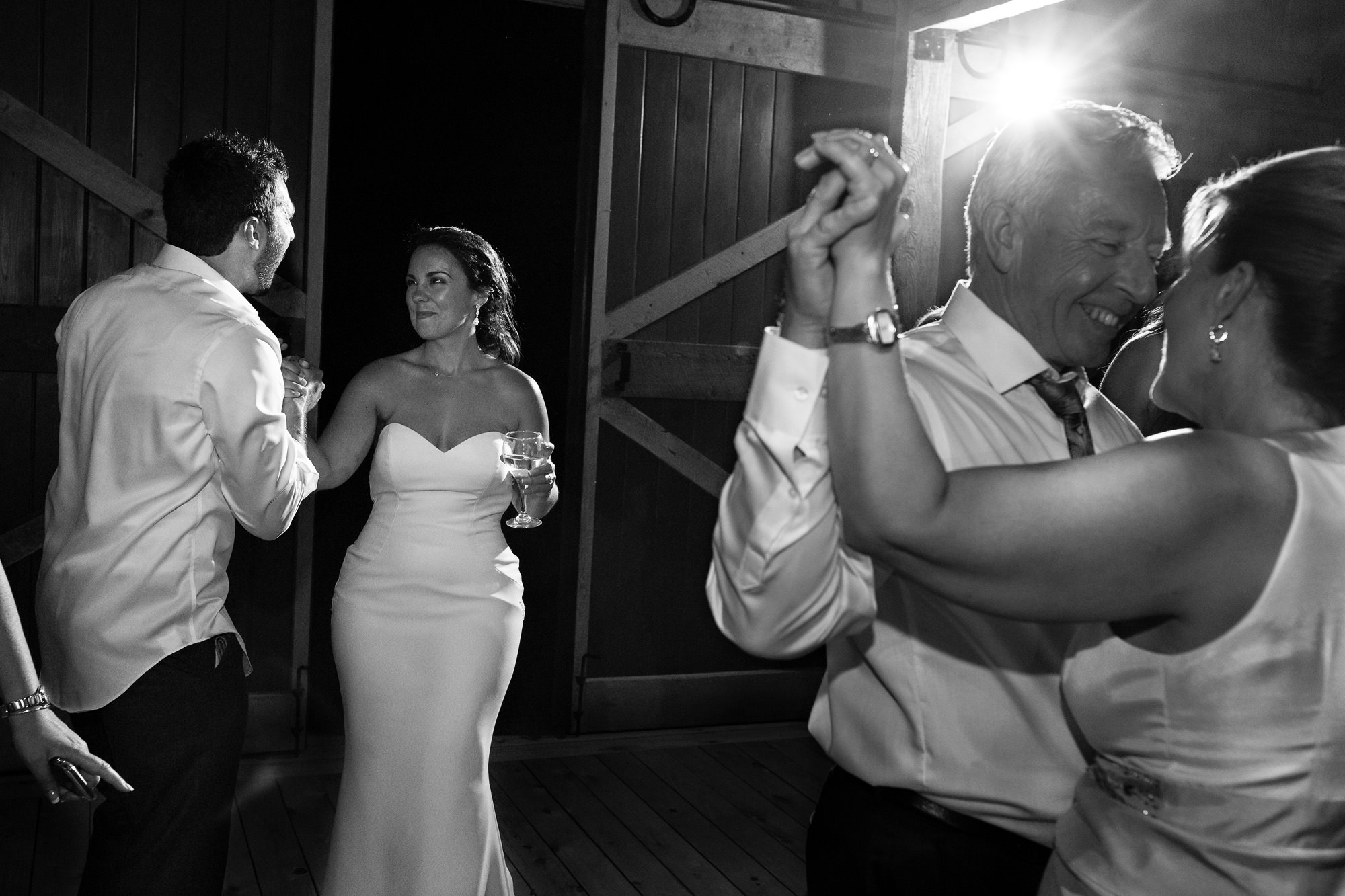 The bride and groom dance with friends and family at their destination barn wedding in Maine