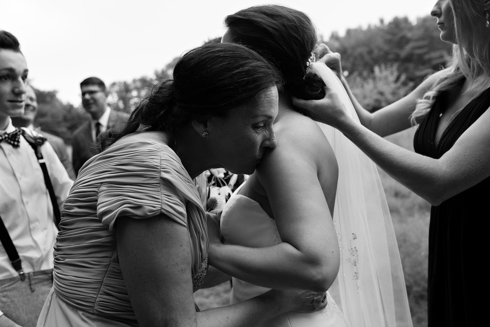 A mother of the bride and the bride share an intimate moment after the wedding ceremony