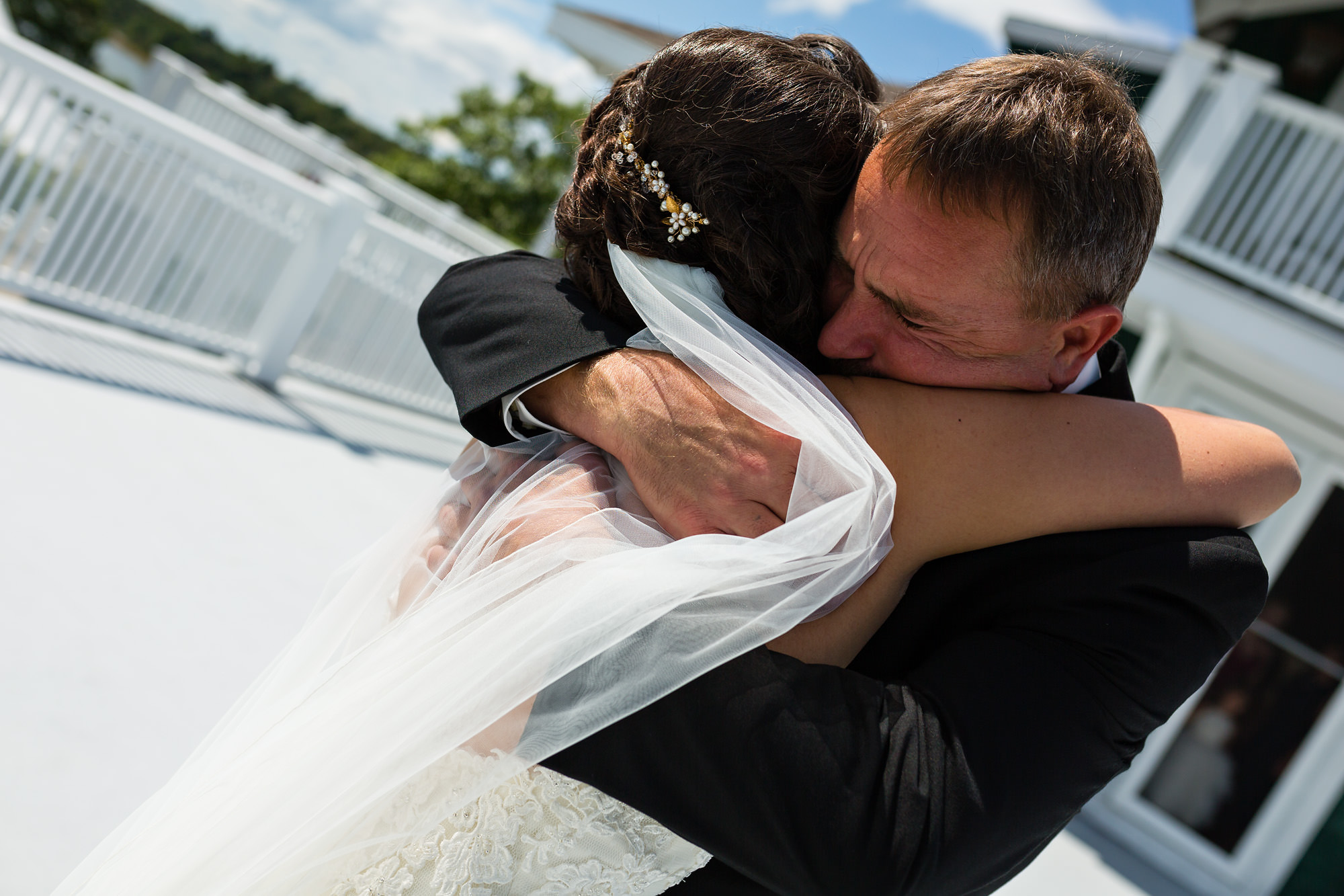 A bride and her dad hug on her wedding day in Maine