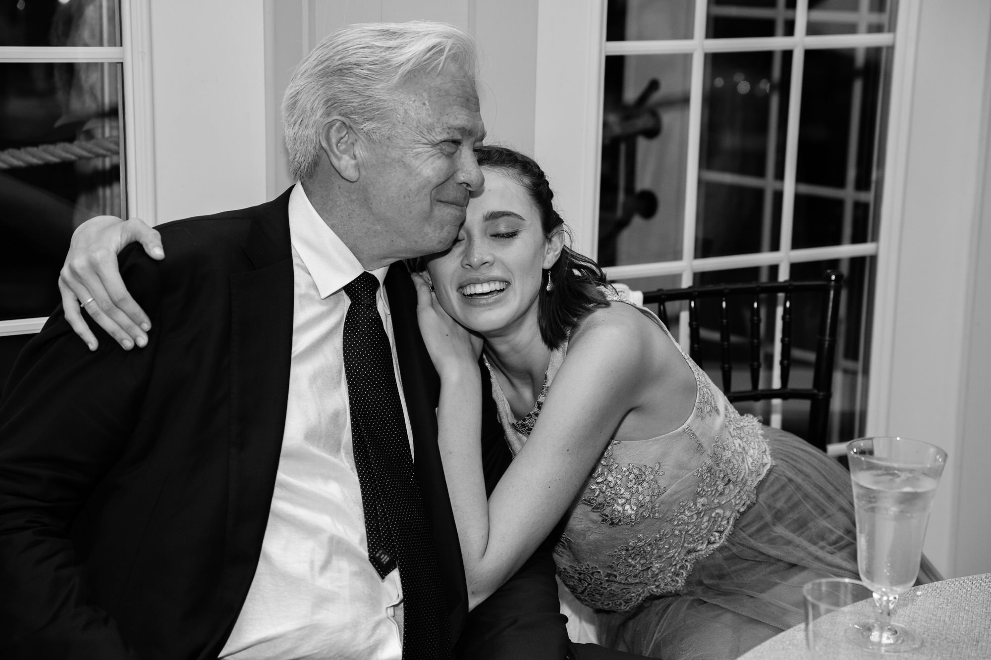 A father and his daughter enjoy a happy moment at a wedding reception.