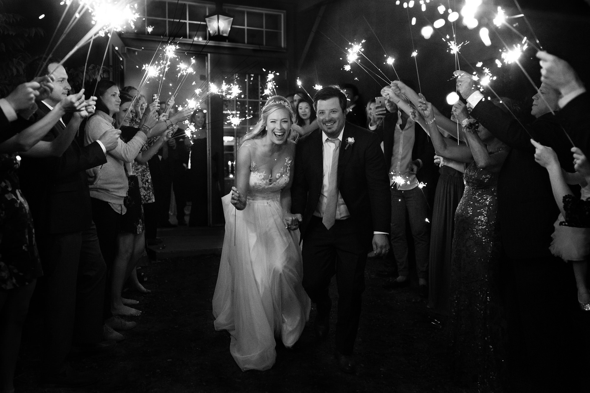 A bride and groom happily enjoy a sparkler exit at Hidden Pond in Kennebunkport, Maine