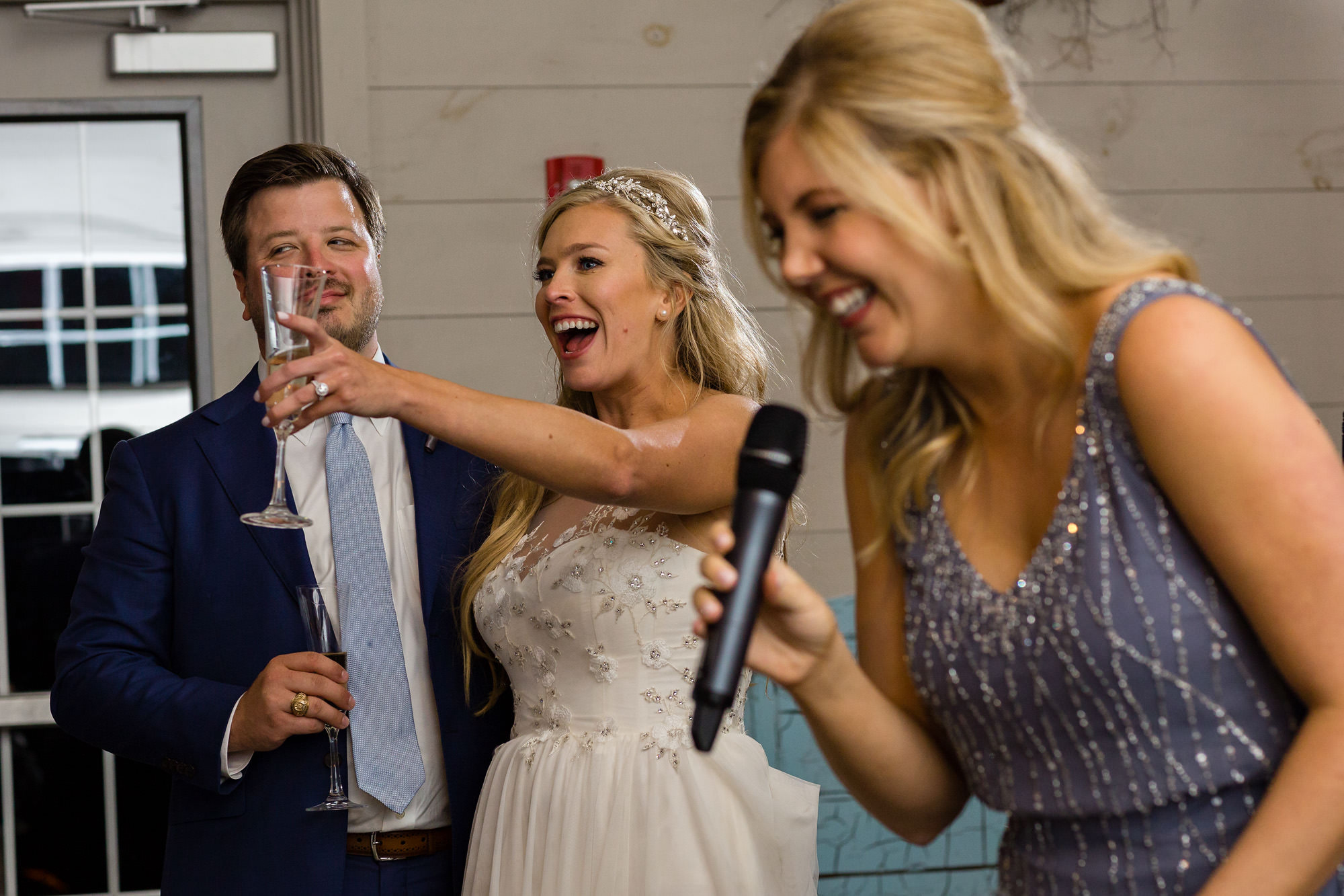 A bride and groom enjoy a toast by the maid of honor at their Maine wedding.