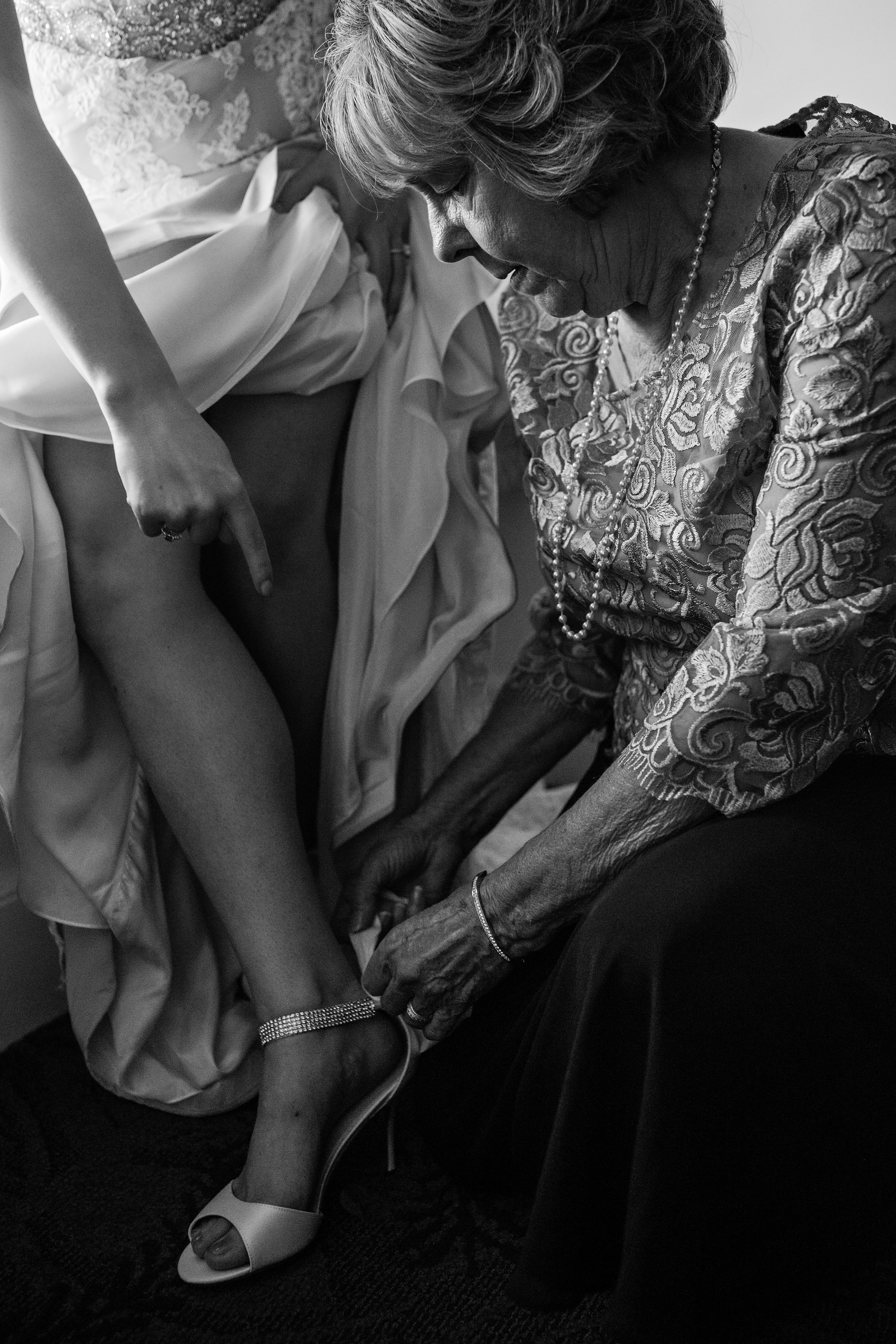 A grandmother helps her granddaughter become a bride on her wedding day in Bar Harbor Maine.