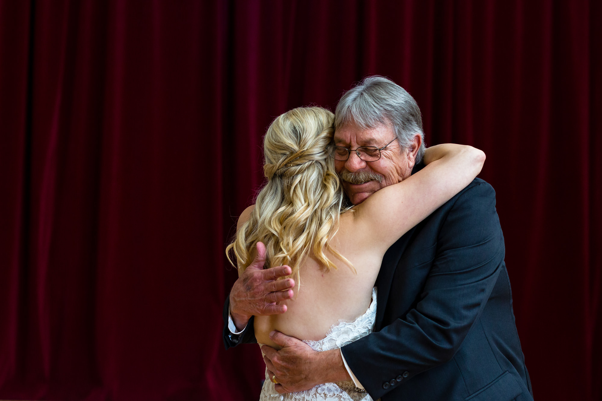 A father hugs his daughter on her wedding day in Maine