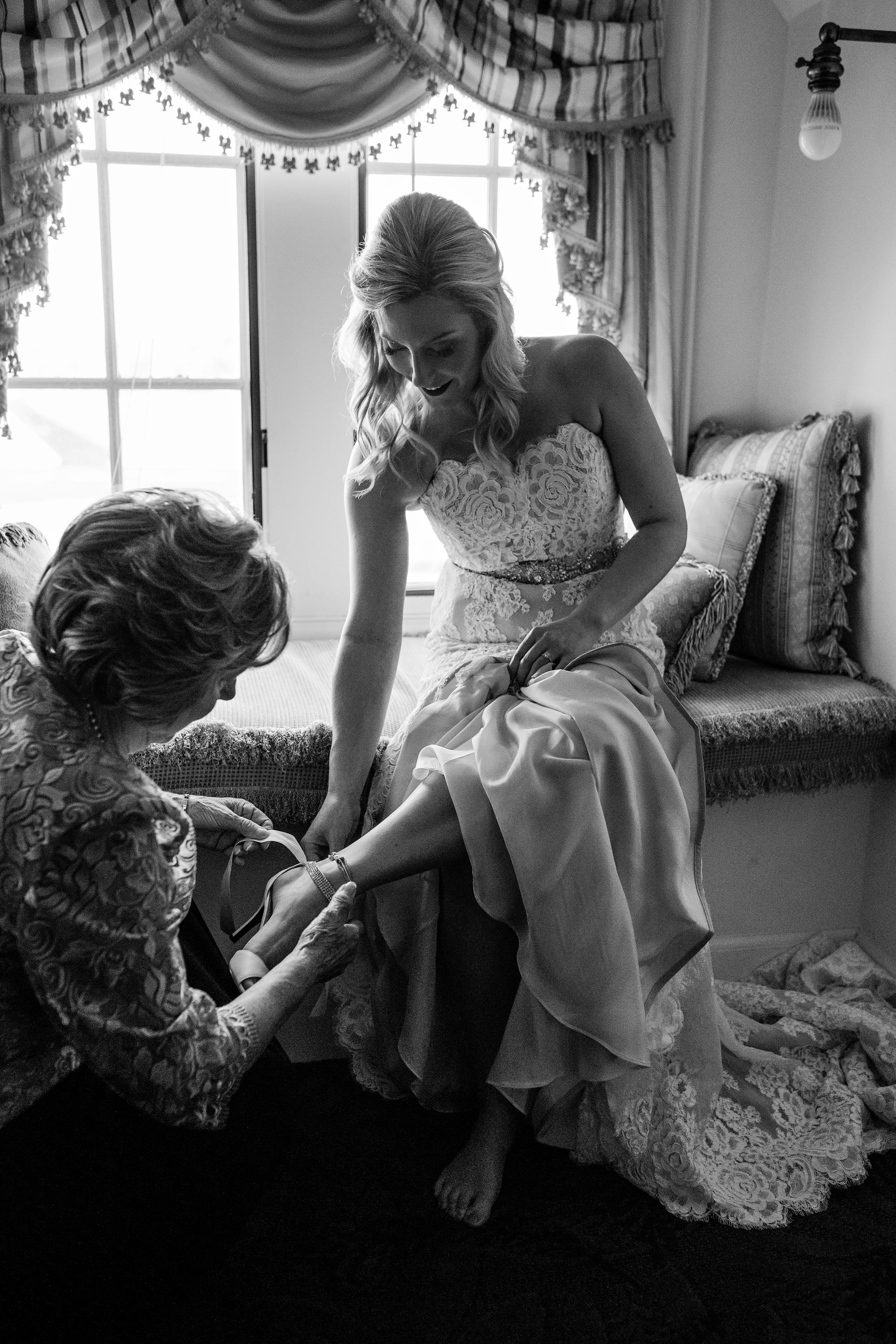 A grandmother helps the bride into her dress at her Bar Harbor Club wedding