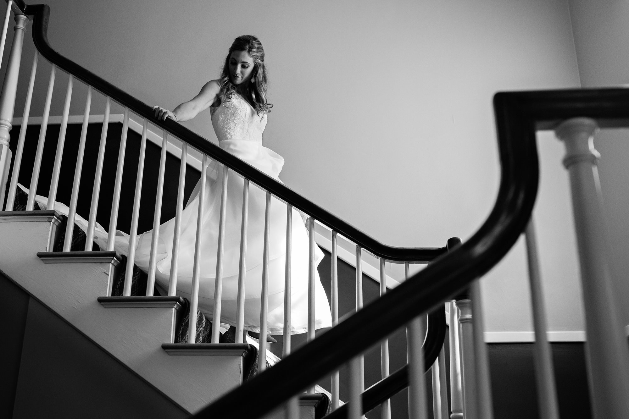 A bride walks down the stairs at the Bar Harbor Inn