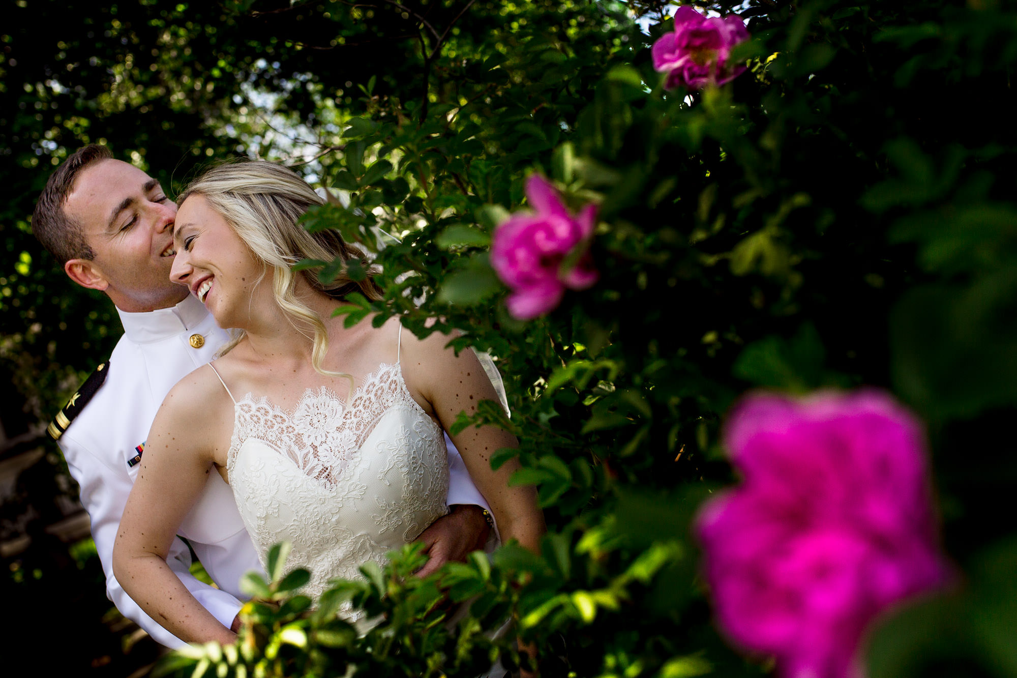 A bride and groom wedding portrait in front of flowers in Camden, Maine