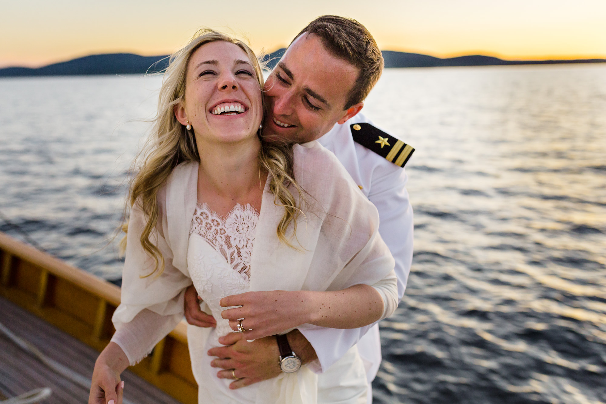 A bride and groom enjoy the sunset on their ride home on the Schooner Olad after their wedding.