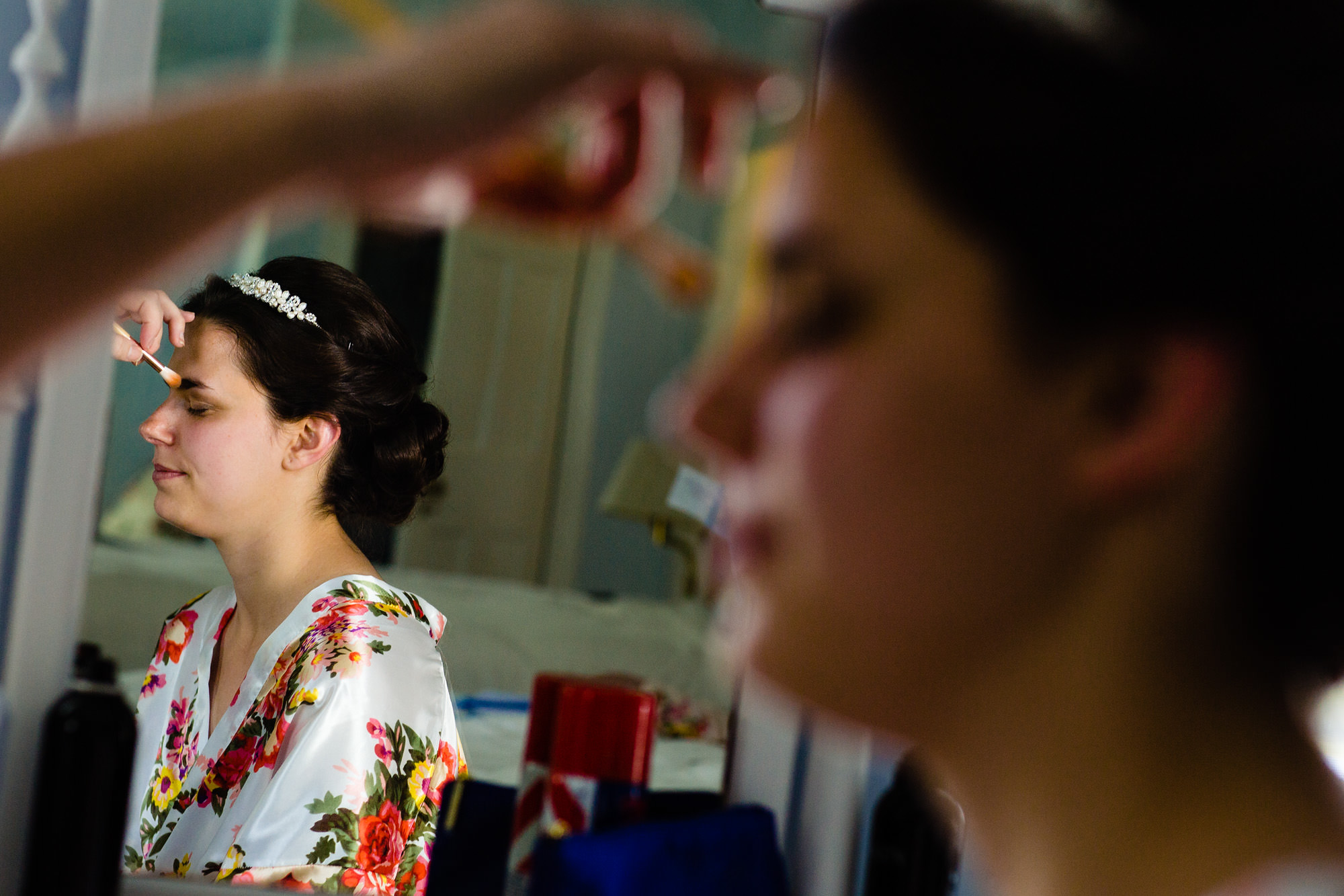 A bride has her makeup applied at her Maine island wedding