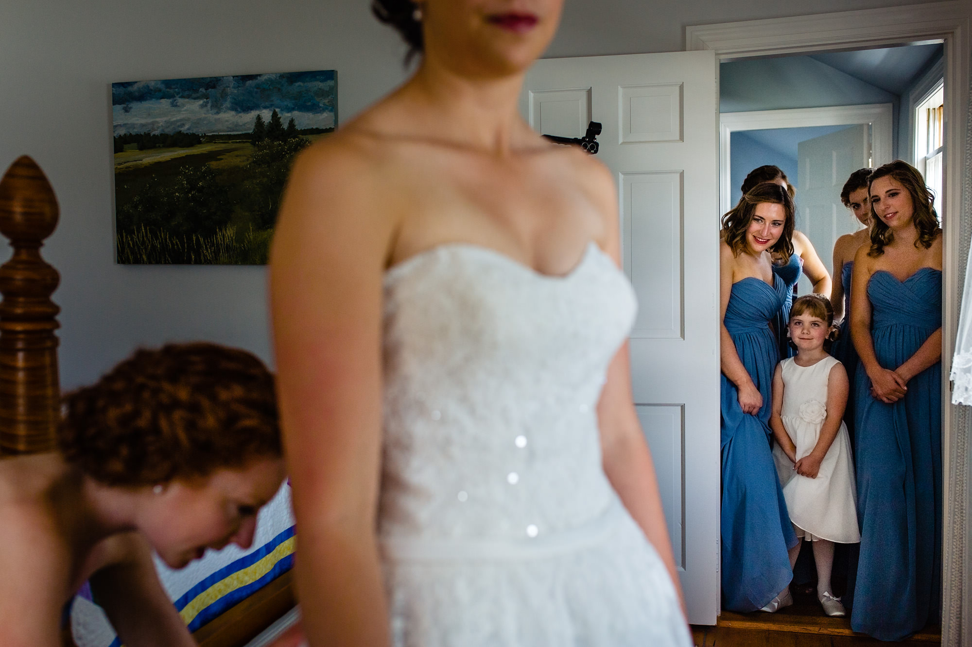A bride puts on her wedding dress at her Maine island wedding