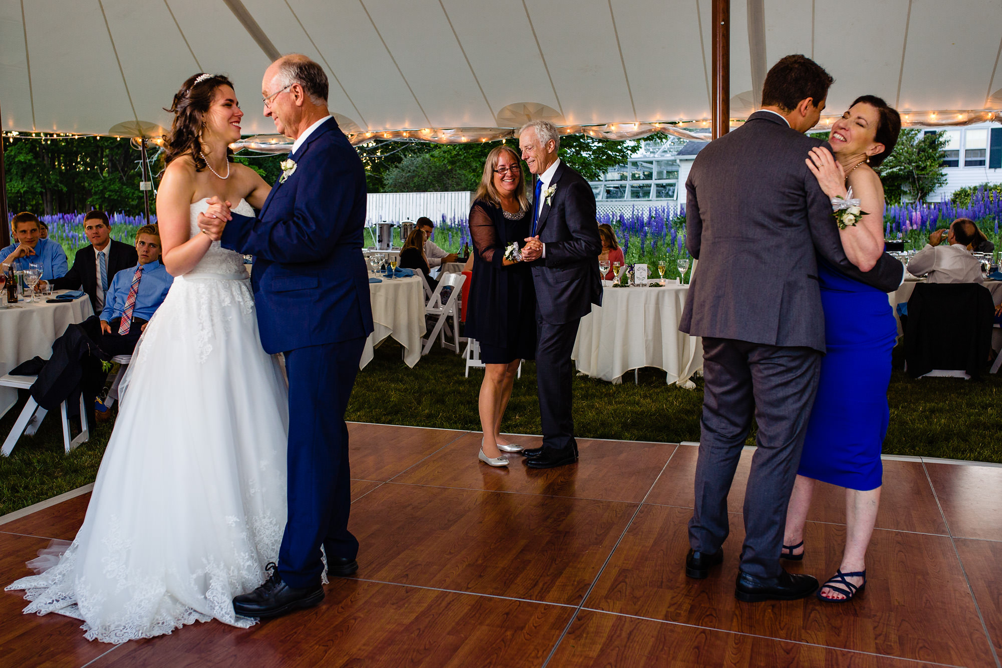 The bride, groom, and their parents share a dance at their Maine island wedding.