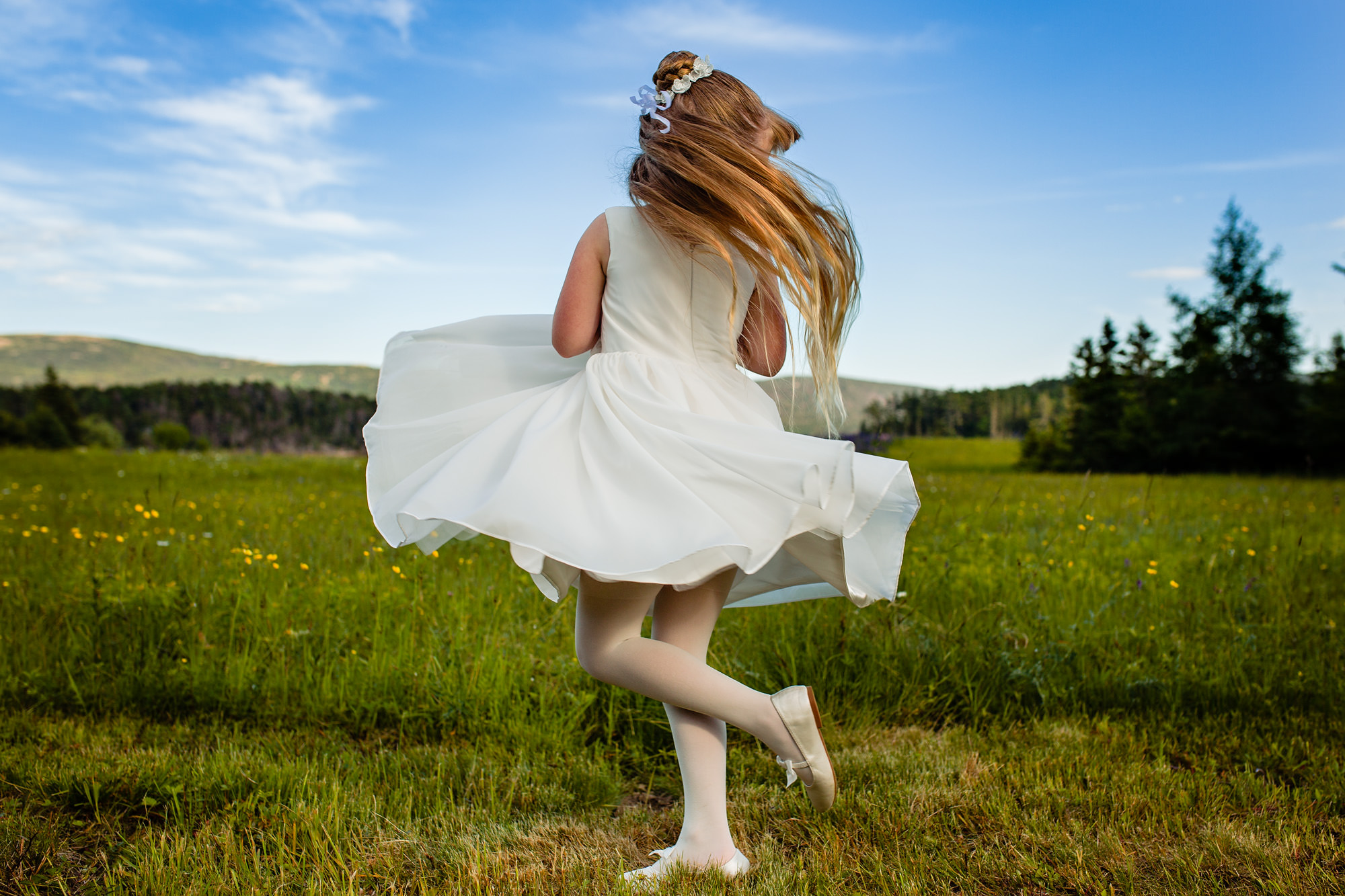A flower girl twirls at a coastal Maine wedding