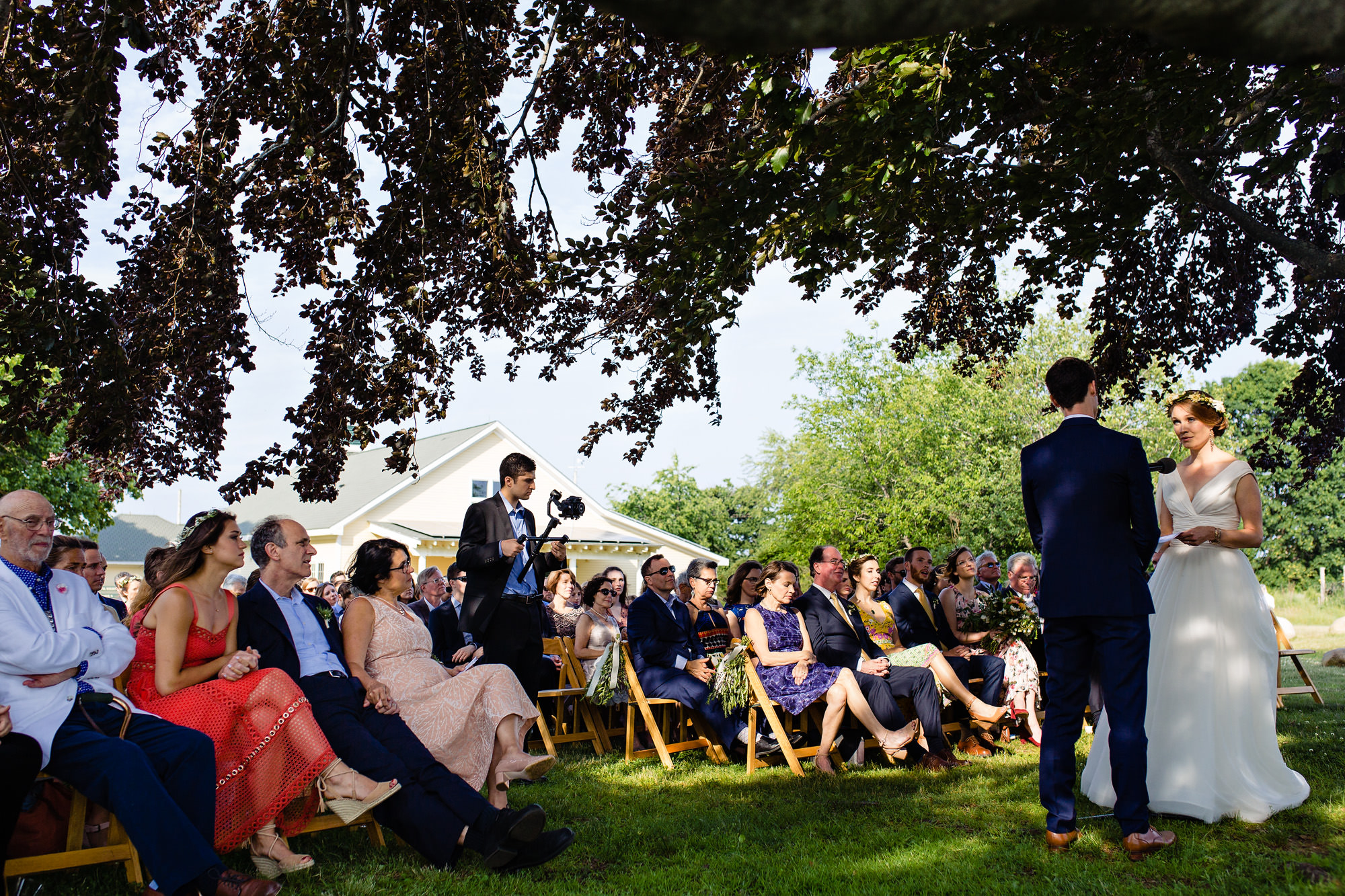 A beautiful wedding ceremony under a tree at Lauldholm Farm in Wells, Maine