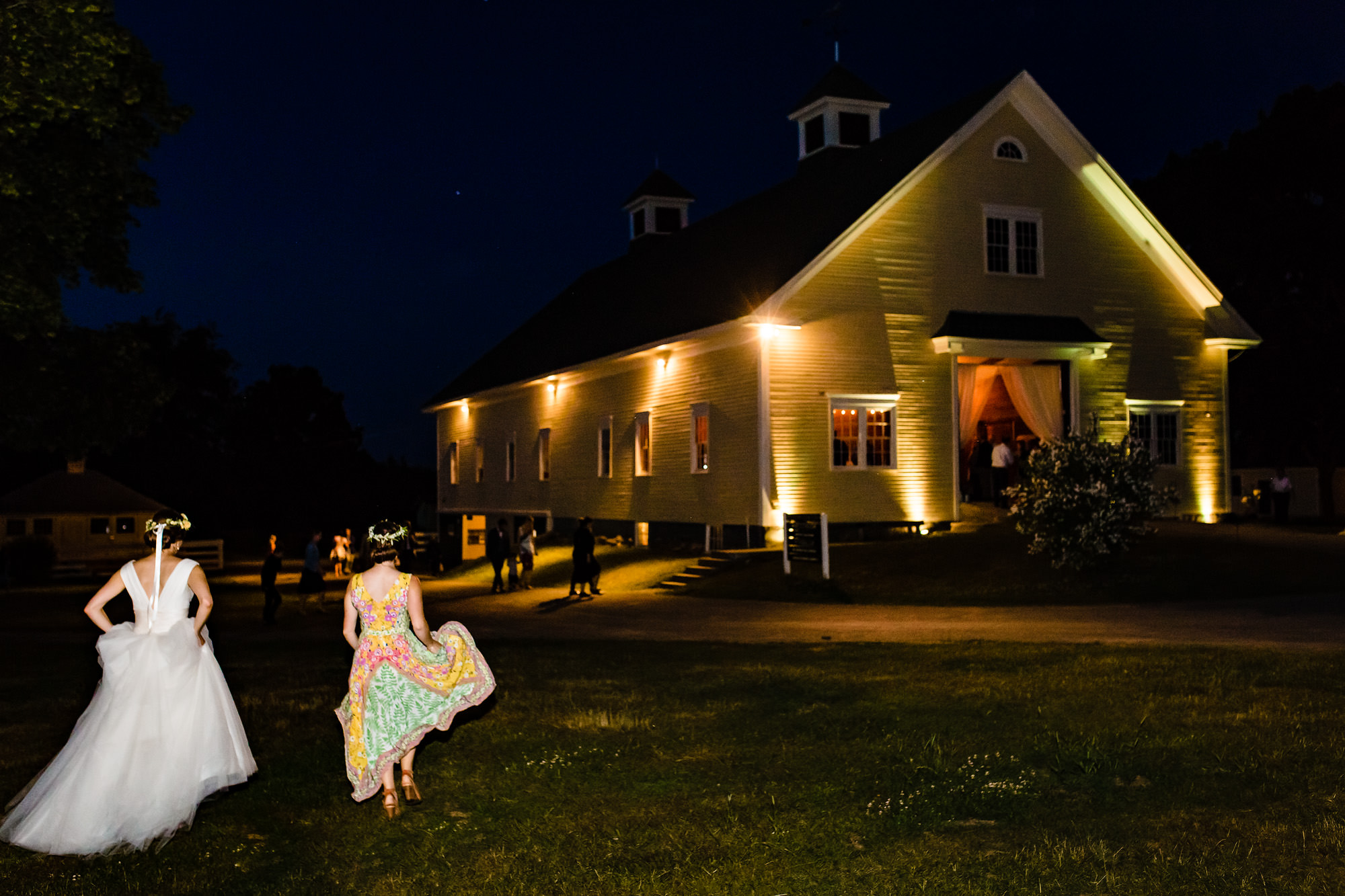 The bride and a friend walk to the barn at Laudholm farm to begin dancing.