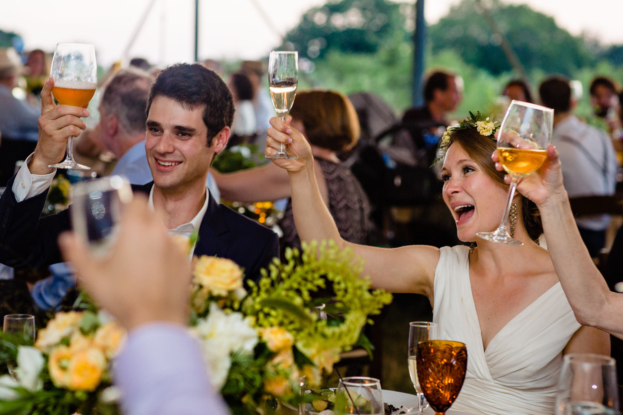 A bride and groom cheer at their Wells Reserve at Laudholm Farm wedding in Maine