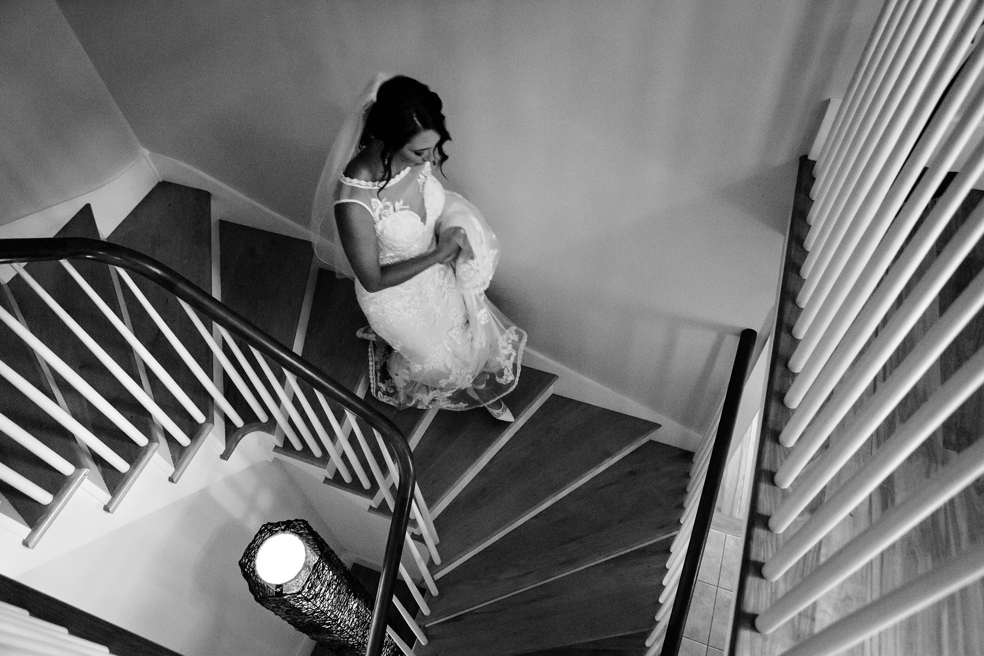 The bride walks down the stairs toward her wedding ceremony in Manchester Maine