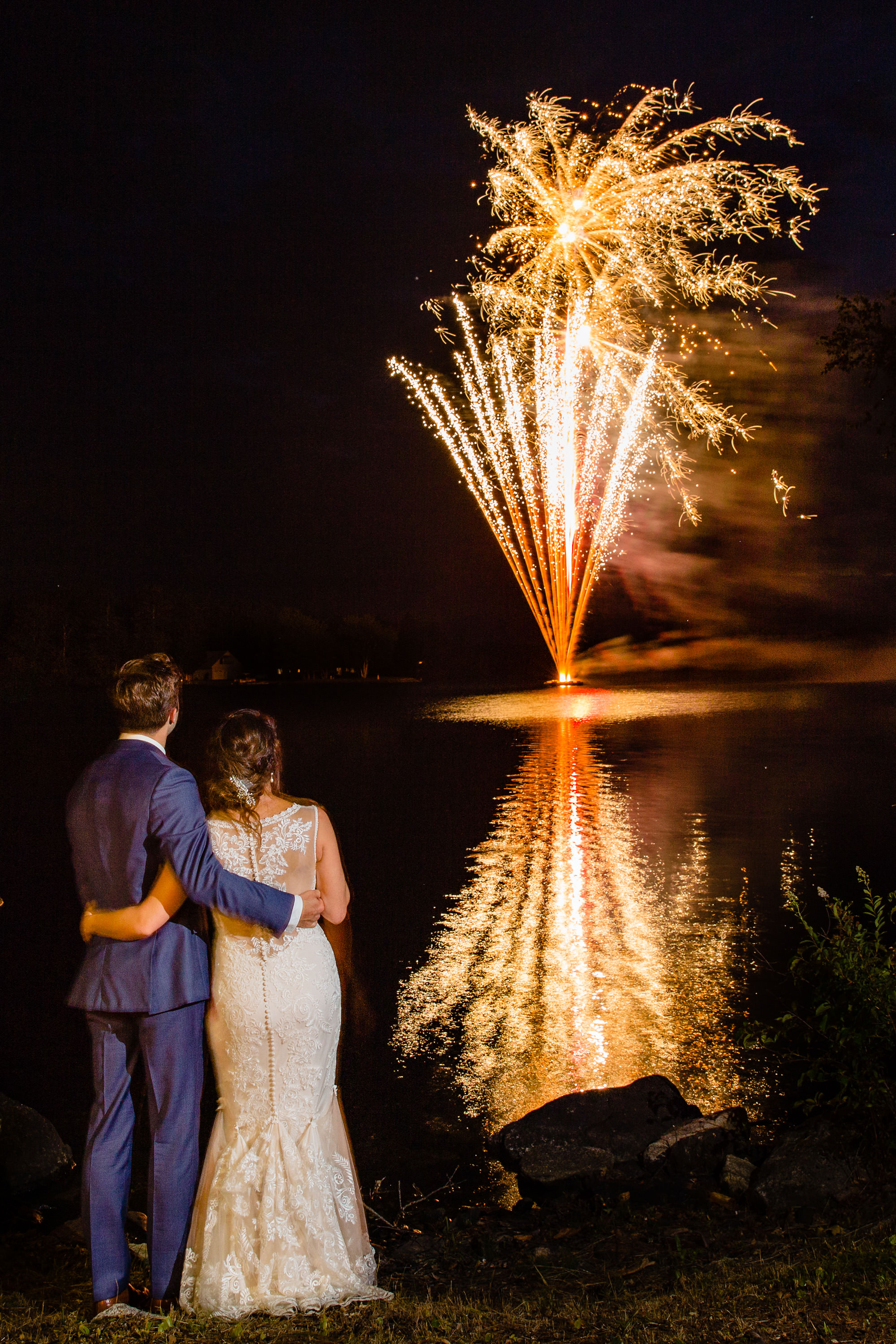 A bride and groom watch fireworks at their private residence Maine wedding