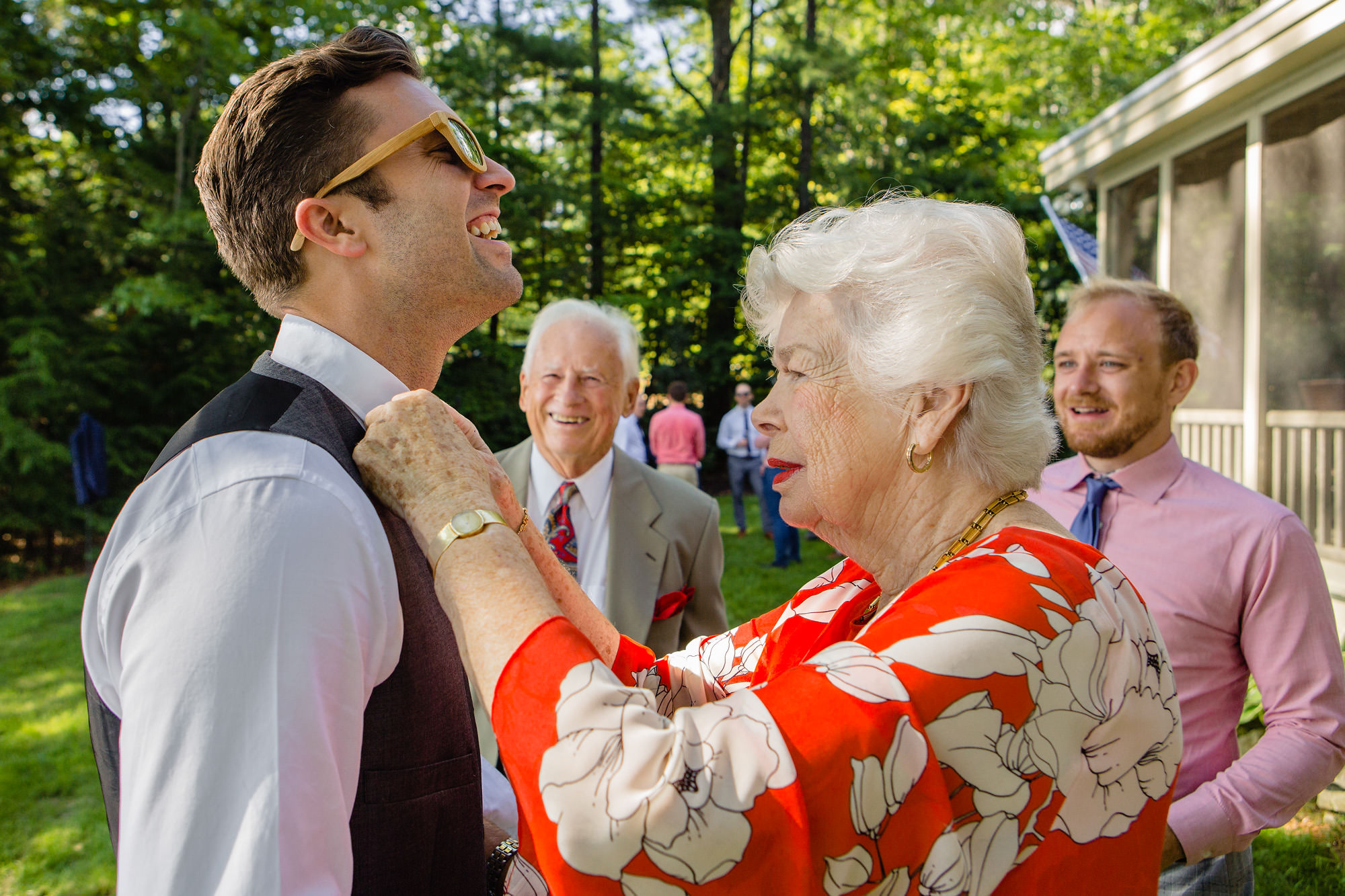 The groom's grandmother helps with his bow tie at his Maine wedding.