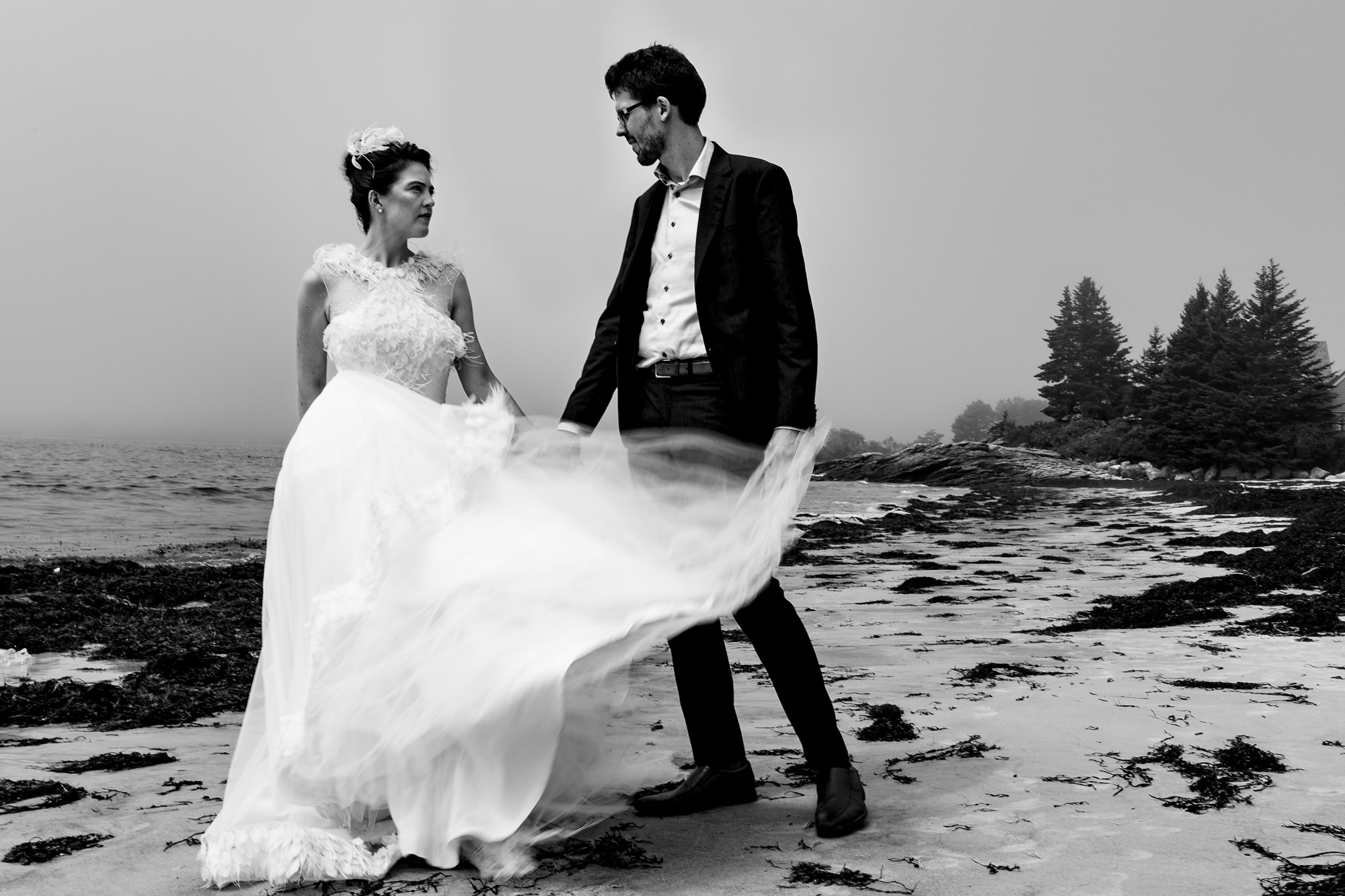 A bride and groom take wedding portraits at Pemaquid Beach in Bristol, Maine
