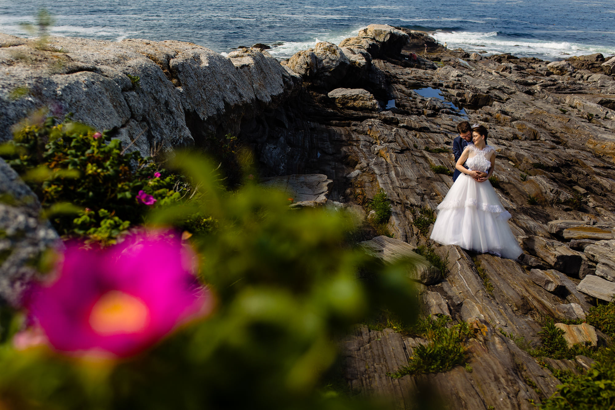 A bride and groom take wedding portraits at Pemaquid Point Lighthouse in Maine