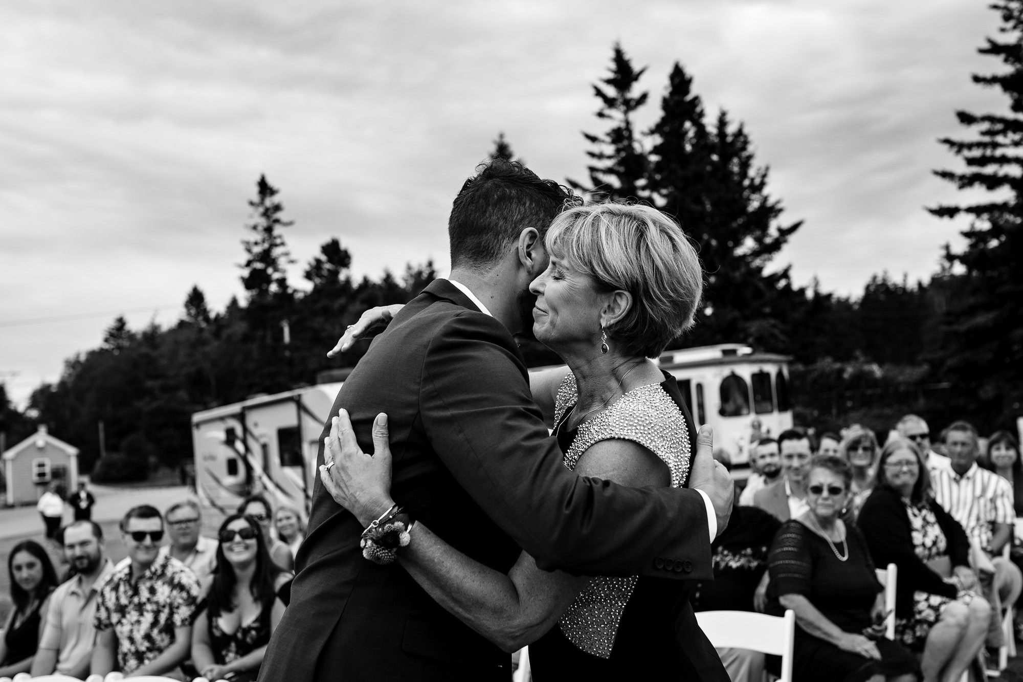 A groom hugs his mom at his Pemaquid Point Lighthouse ceremony