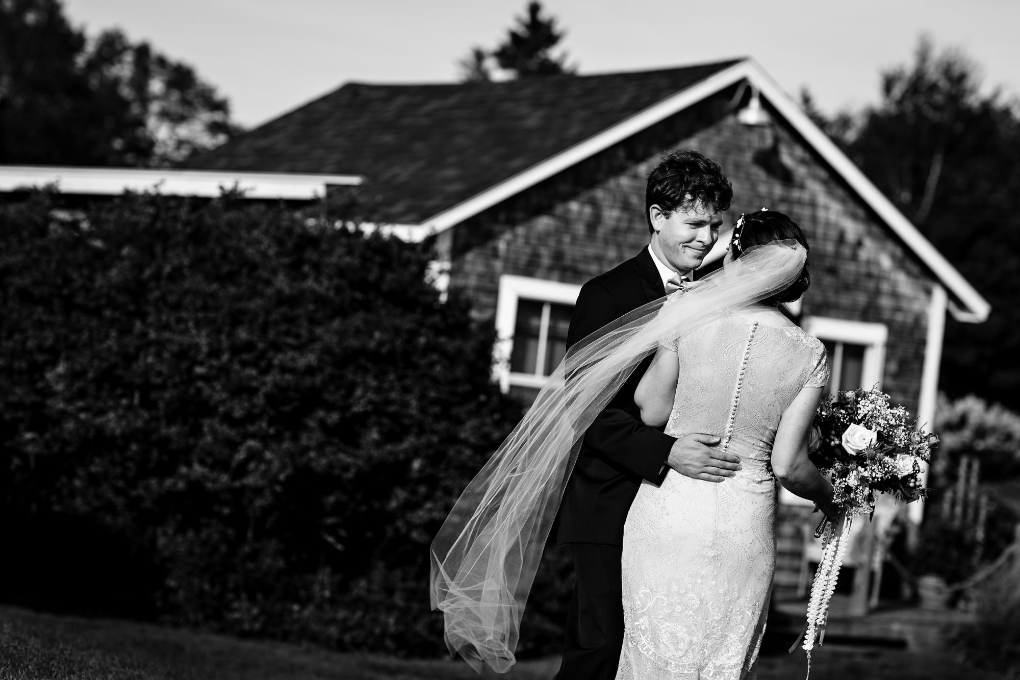 The bride and groom share a candid moment at their midcoast Maine wedding