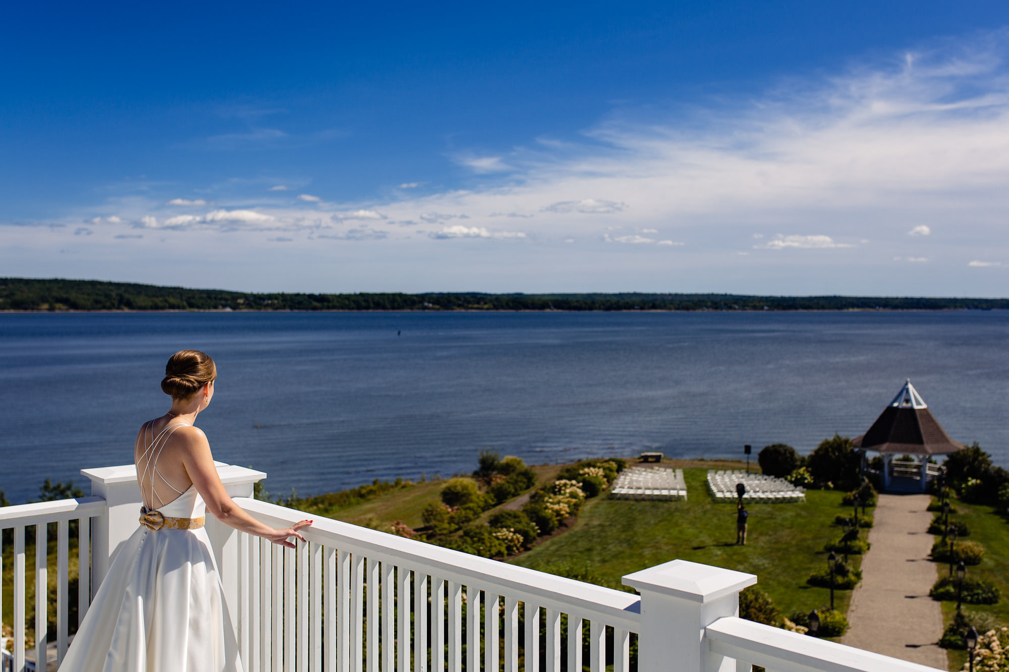 A bride stands on the balcony of French's Point overlooking the ceremony site.