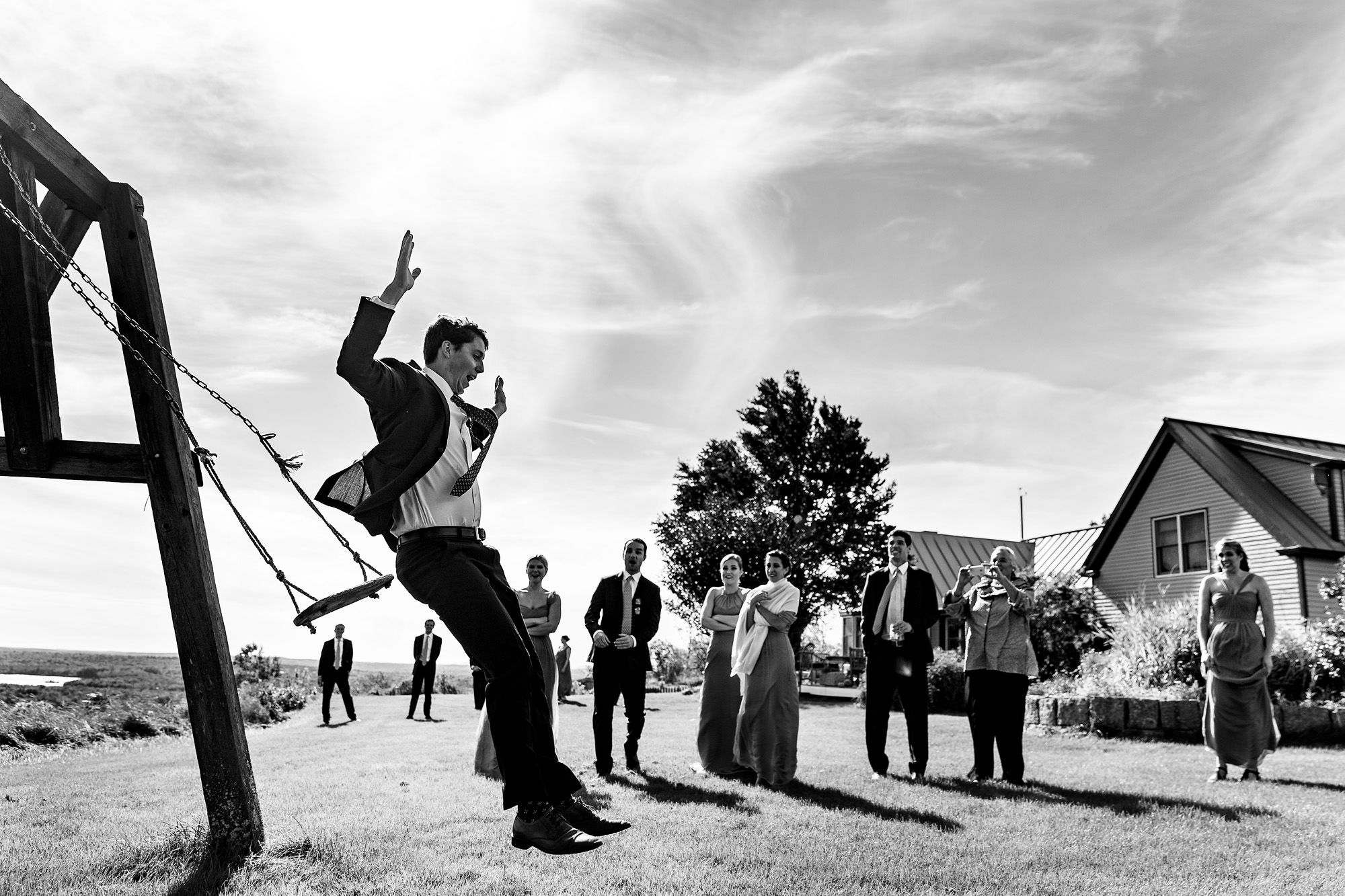 A groom swings before their Maine wedding