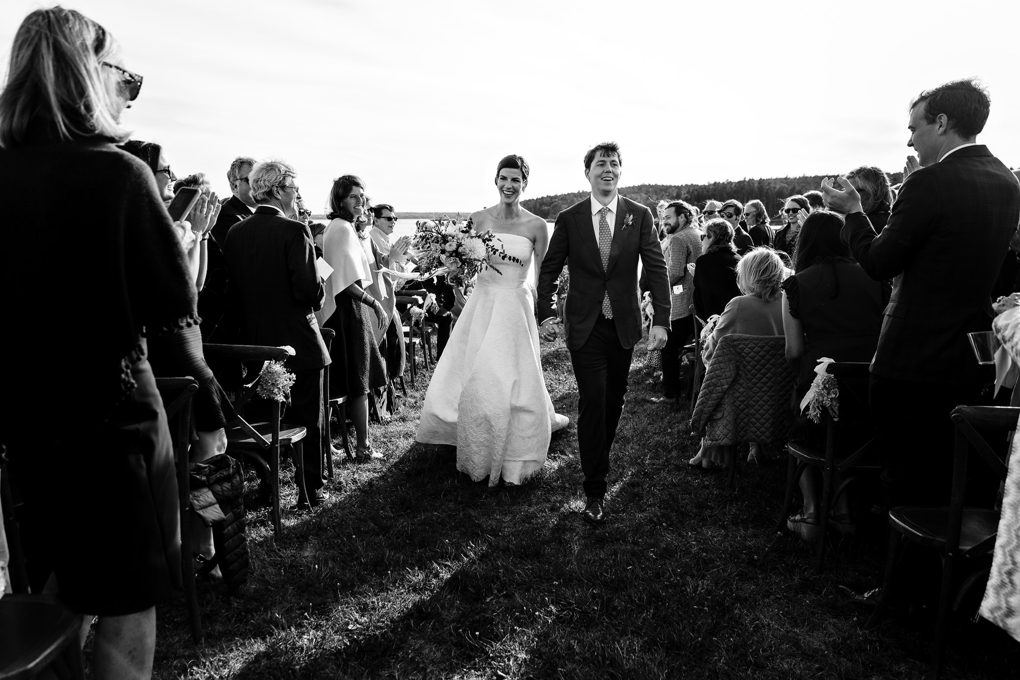 A newly married couple walks down the aisle of their wedding ceremony in Maine