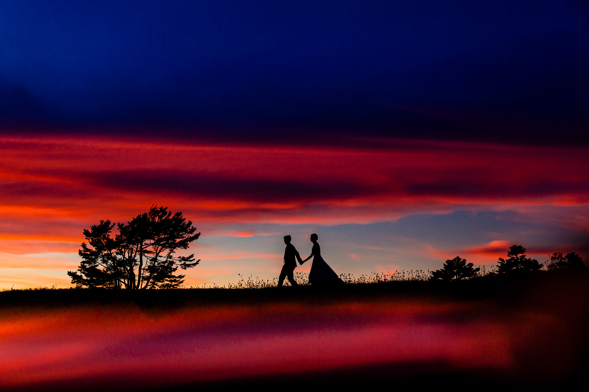 A creative wedding day portrait of the bride and groom taken at sunset in Maine