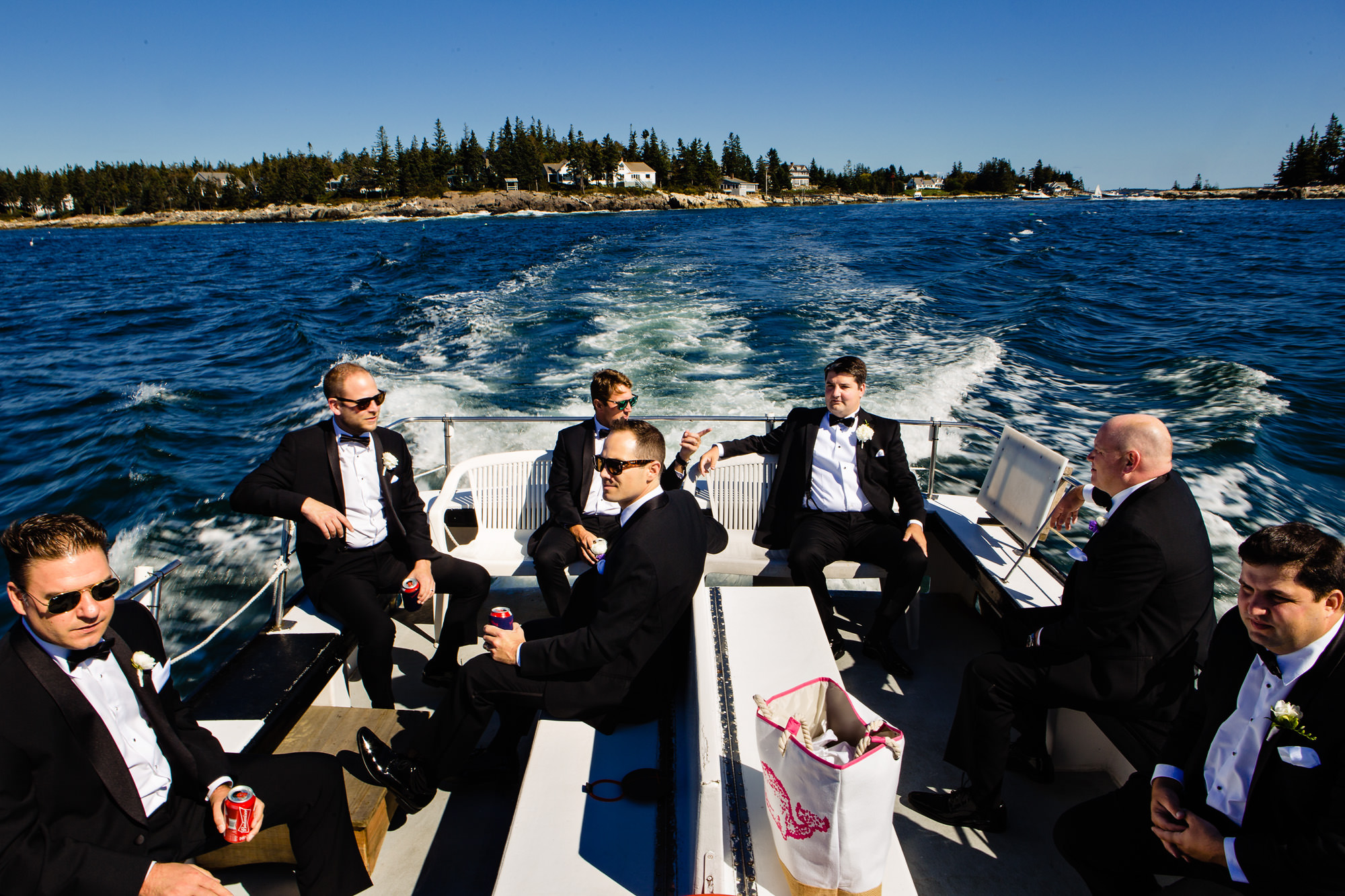 A groom and his groomsmen boat over to his wedding in Boothbay Harbor, Maine