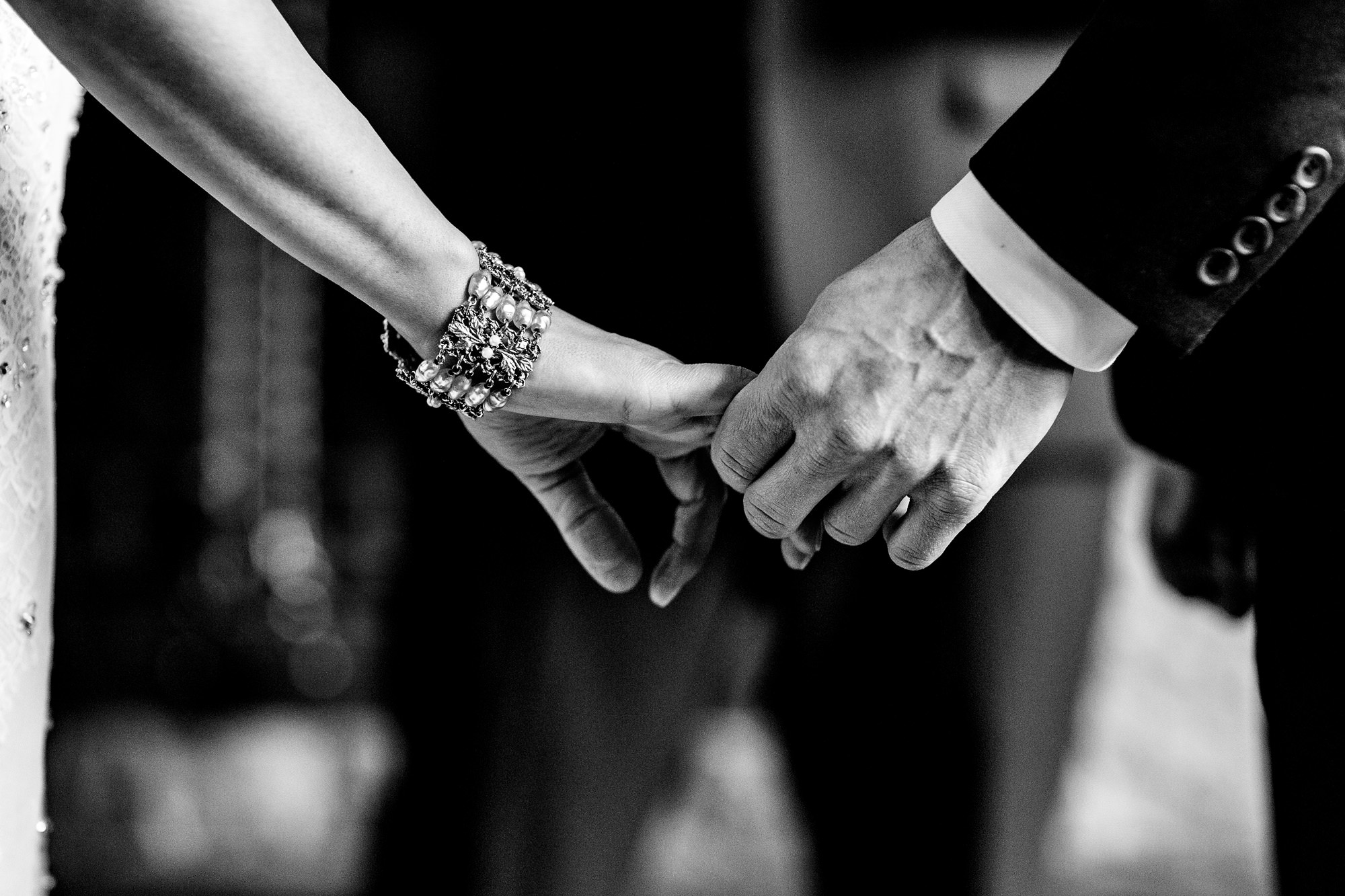 A bride and groom hold hands during their wedding ceremony at Moose Lake Ranch in western Maine