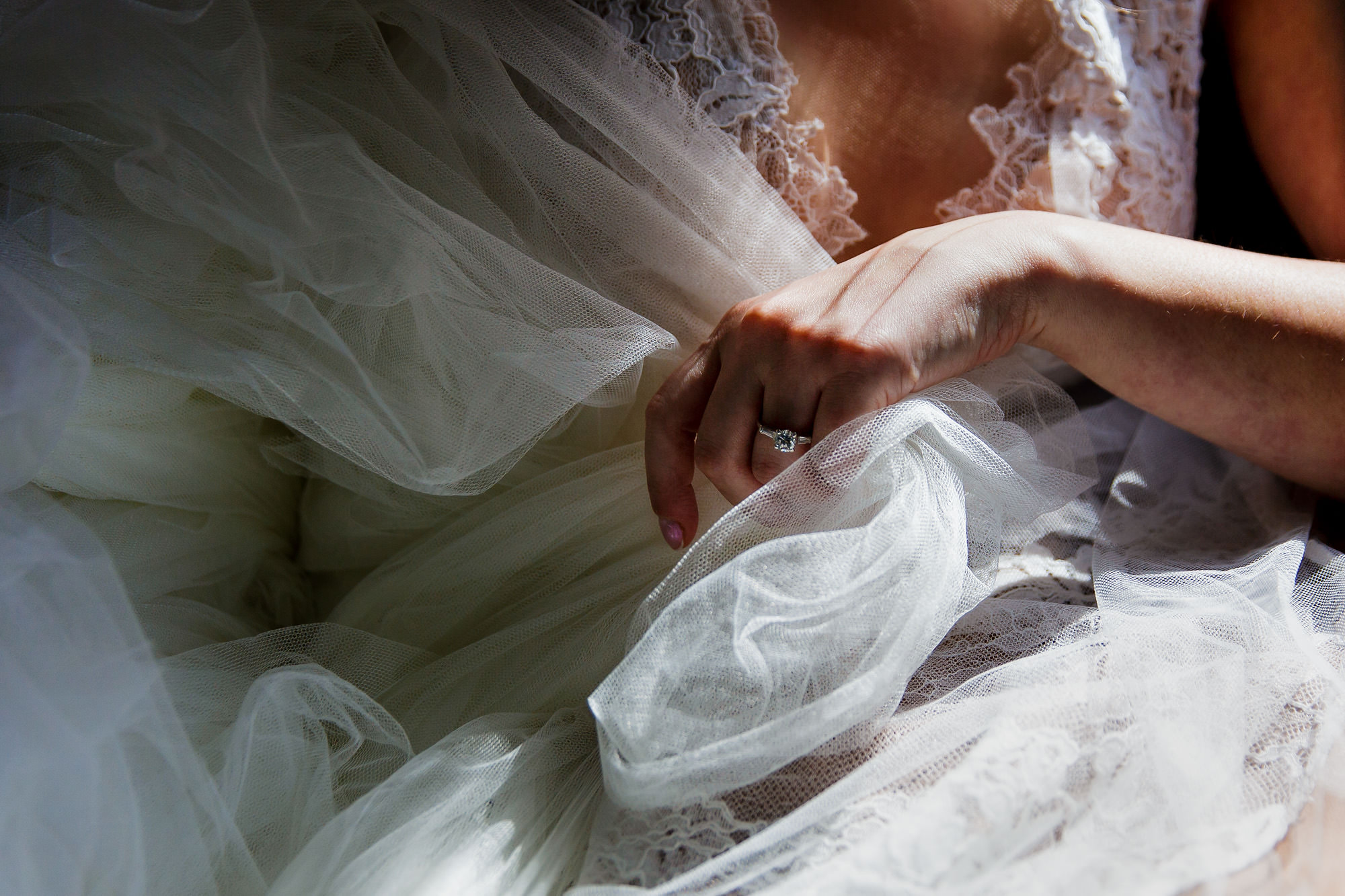 A bride pulls bugs out of her tulle dress at her Maine wedding