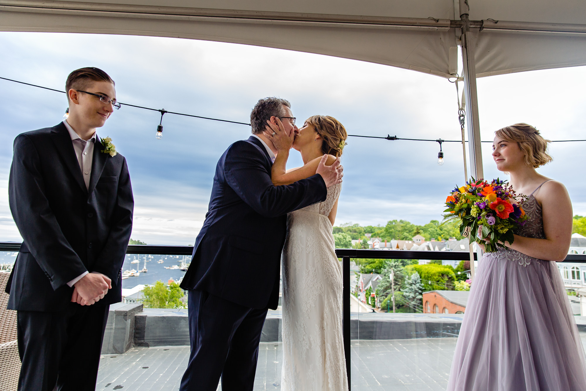 A bride and groom during their wedding ceremony on the top of 16 Bay View in Camden, Maine