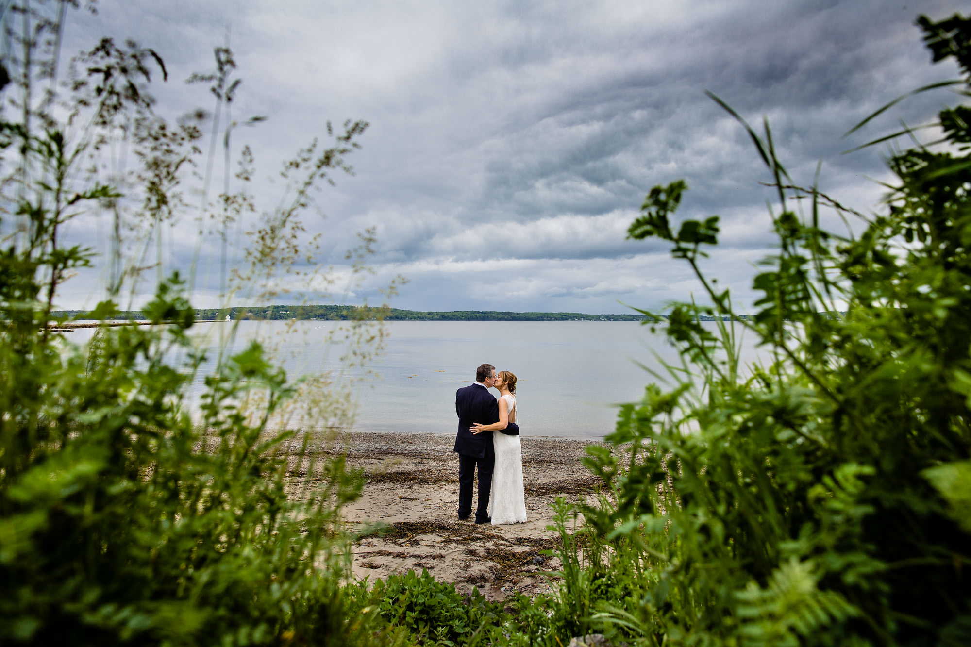 A bride and groom take wedding portraits at the Rockland Breakwater in Maine