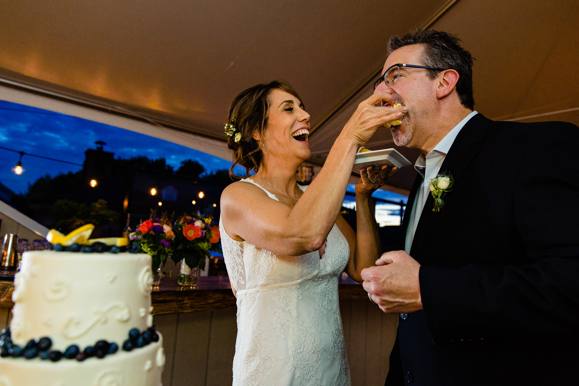 A bride and groom share wedding cake in Camden, Maine